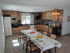 a kitchen with a table with chairs and a refrigerator at Villa a 10 km de Alicante y playas in Elche