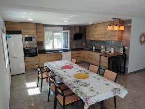 エルチェにあるVilla a 10 km de Alicante y playasのキッチン(テーブル、椅子、冷蔵庫付)