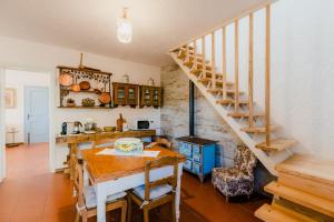 a kitchen and dining room with a wooden table and stairs at la tana del geco in Massarosa