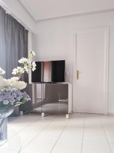 een witte woonkamer met een tv en een deur bij LasStory Apartment in Torrevieja