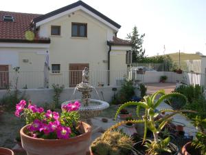 un jardín con flores y una fuente frente a una casa en B&B Angolo Felice, en Matera