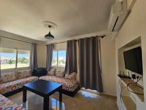 a living room with a couch and a tv at Mosaic Appartments in Tetouan
