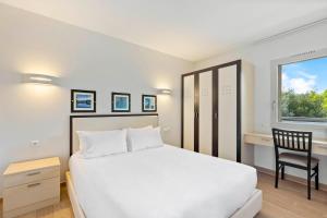 - une chambre avec un lit, un bureau et une fenêtre dans l'établissement Résidence Cala Sultana Appartement T2, à Porto-Vecchio