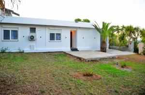 a white house with a palm tree in a yard at J&M FALIRAKI in Faliraki