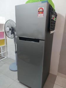 um frigorífico numa cozinha com uma ventoinha em S99 HOMESTAY KUDAT em Kudat