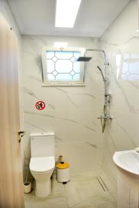 a bathroom with a toilet and a sink and a window at J&M FALIRAKI in Faliraki
