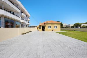 uma entrada que leva a uma casa com um edifício em Pontes Guest House em Arcozelo