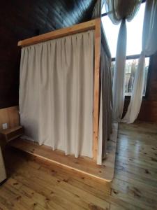 a curtain in a room with a wooden floor at CABANAS CHEIRO DE MATO in Cambará