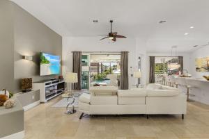 een woonkamer met een witte bank en een plafondventilator bij LUXURY VILLA AWENASA * experience the vacation of your dreams in Cape Coral