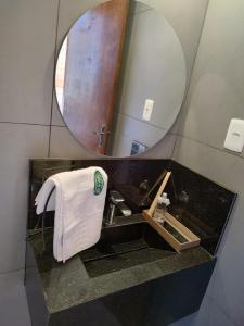 a bathroom with a sink and a mirror and a towel at CABANAS CHEIRO DE MATO in Cambará
