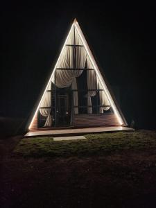 a house with a triangular roof in the dark at CABANAS CHEIRO DE MATO in Cambara do Sul