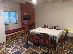 a dining room with a table and chairs and a tv at Vineyard of Valta in Marmari