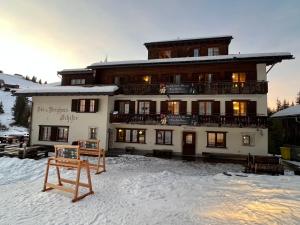 a building in the snow with a sign in front of it at Schifer Berghaus in Klosters