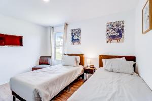 2 Betten in einem Zimmer mit weißen Wänden in der Unterkunft Staycation Cottage in San Antonio
