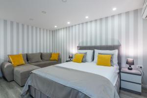 a bedroom with a large bed and a couch at Small, sweet & cosy apartments in Rijeka
