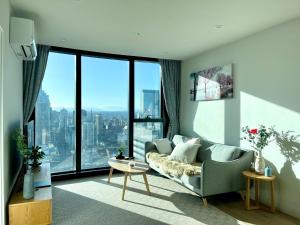 een woonkamer met een bank en een groot raam bij Sweet Home Apartment Melbourne CBD in Melbourne
