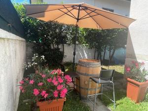 einen Regenschirm, einen Stuhl, ein Fass und Blumen in der Unterkunft BLUE SEA Villa in Lido di Camaiore