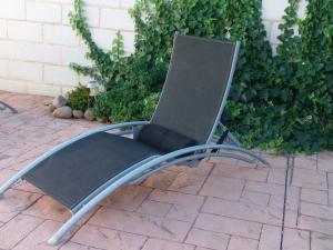 a black chair sitting on a brick patio at Casa rural La sastreria de Adanero in Adanero