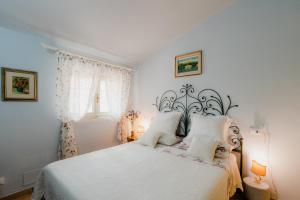 a bedroom with a white bed with white pillows at la tana del geco in Massarosa +49 photos