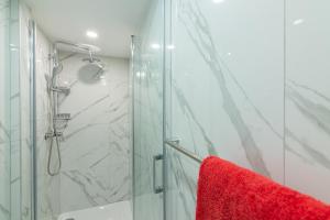 a bathroom with a shower and a red towel at Small, sweet & cosy apartments in Rijeka +14 photos