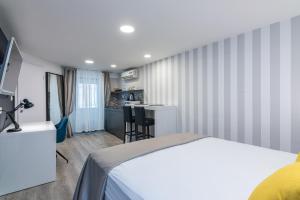 a hotel room with a bed and a kitchen at Small, sweet & cosy apartments in Rijeka