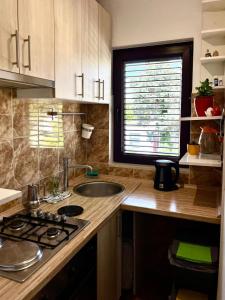 una cucina con lavandino e bancone con finestra di Apartment Leda a Kraljevica (Porto Re)