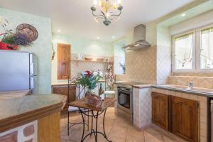 a kitchen with a sink and a stove top oven at La Villanelle  +9 photos
