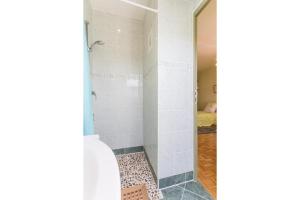 um chuveiro com uma porta de vidro na casa de banho em La Villanelle 