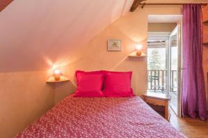 um quarto com uma cama vermelha e 2 almofadas vermelhas em La Villanelle 
