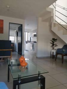 sala de estar con mesa de cristal y escalera en Casa como nueva, cómoda y tranquila, en Guadalajara