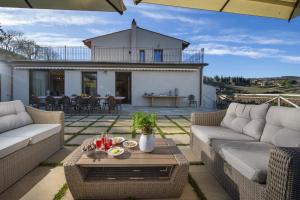 a living room with couches and a table on a patio at Villa il Giardino - Homelike Villas in Greve in Chianti