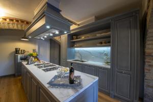 a kitchen with a counter with a bottle of wine at Villa il Giardino - Homelike Villas in Greve in Chianti