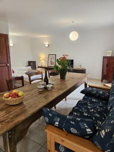 sala de estar con mesa de madera y sofá en L'AUBERGE DE LA PORTE, en Saint-Jouan-des-Guérets