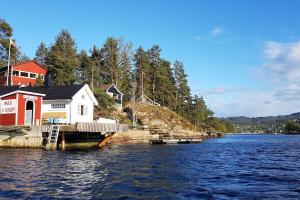 una casa en la orilla de un cuerpo de agua en Sætre, Asker, egen båt ,kajakk,jacuzzi, rolig sted, en Asker