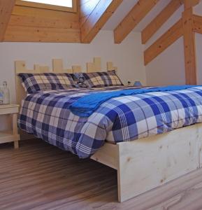 a bed in a room with a wooden bed frame at Le Castagne Matte in Stenico