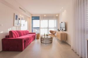 a living room with a red couch and a tv at AMALON Boutique Apartments in Jerusalem