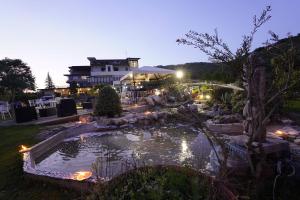 een vijver in een tuin met een gebouw op de achtergrond bij Hotel Ristorante La Ripa in Fiuggi