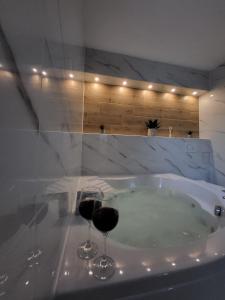 two glasses of wine sitting in a bath tub at Apartment Dado in Slunj