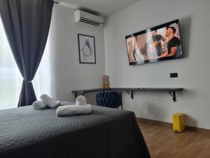 a bedroom with a bed with a tv on the wall at Lux Room 303 in Zadar