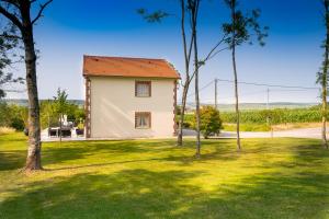 a small house in a grassy yard with trees at Le Champaillé in Dormans