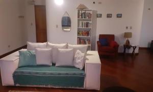 ein weißes Sofa mit Kissen im Wohnzimmer in der Unterkunft Apartamento no Morro do Elefante (Capivari) in Campos do Jordão