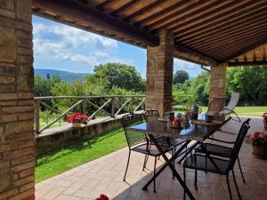 einen Tisch und Stühle auf einer Terrasse mit Aussicht in der Unterkunft Villa Il Fontanino in Monticiano