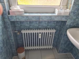 a bathroom with a radiator and a window and a sink at Ferienwohnung Eichhörnchen in Krefeld +28 photos