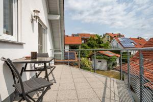 un patio con tavolo e sedie sul balcone. di Diesch a Neukirch