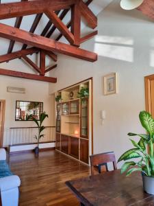 sala de estar con vigas de madera y mesa en Upper Garden Guest House, en Cagliari