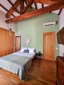 a bedroom with a large bed and a wooden floor at Upper Garden Guest House in Cagliari