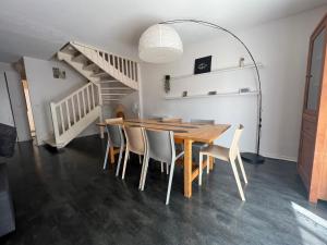 a dining room with a wooden table and chairs at Maison Duplex T4 6 couchages in Gujan-Mestras