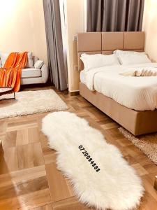 1 dormitorio con cama y alfombra blanca en lovely town studio en Nakuru