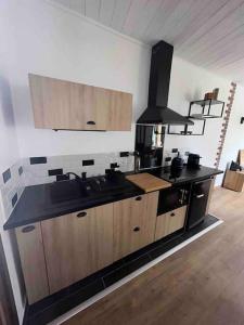 a kitchen with a sink and a stove at Le Refuge de la Gravière in Charleville-Mézières +5 photos