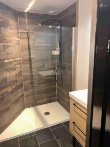 a shower with a glass door in a bathroom at Le Refuge de la Gravière in Charleville-Mézières